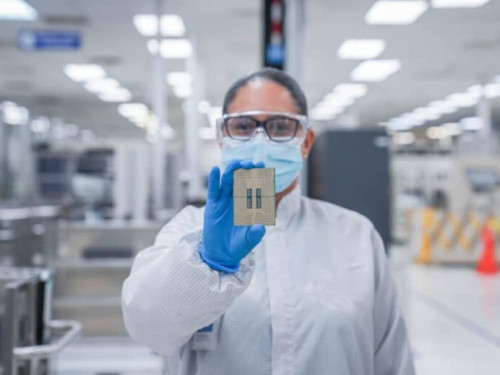 A worker holding up an Intel Xeon chip